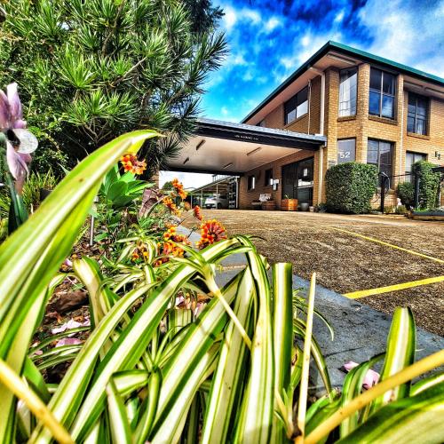 un edificio con un montón de plantas delante de él en Raceview Motor Inn, en Toowoomba