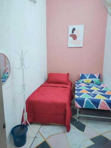 a bedroom with two beds and a lamp in it at Yoni Homestay in Kampung Raja