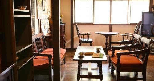 a room with chairs and a table and a table at Izumiya Zenbe in Matsumoto