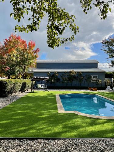 a yard with a swimming pool and grass at Farm Stay HARMONY Cottage at Wilindi Estate in Tyabb