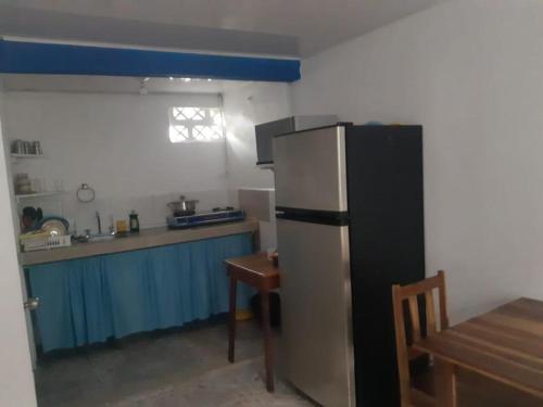 a kitchen with a refrigerator and a table in it at Cabinas Chazu #2 in Quepos