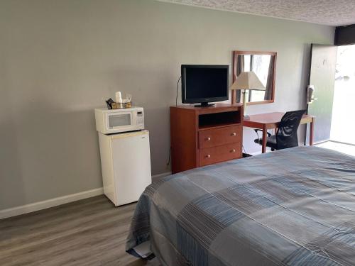 
a hotel room with a television and a bed at Wilkes-Barre Inn & Suites in Wilkes-Barre
