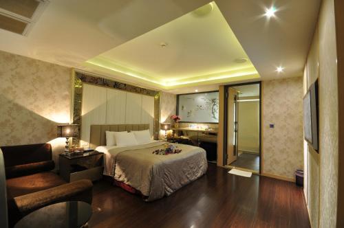 采岩汽車旅館 في تايتشونغ: غرفه فندقيه بسرير وكرسي