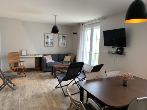 un salon avec un canapé, une table et des chaises dans l'établissement Fort-Mahon-Plage : Appartement rénové en front de mer, 2 chambres, terrasse - FR-1-482-93, à Fort-Mahon-Plage