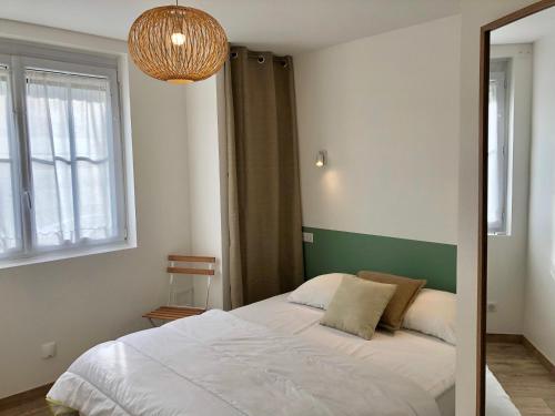 une chambre avec un lit, une fenêtre et un lustre dans l'établissement Fort-Mahon-Plage : Appartement rénové en front de mer, 2 chambres, terrasse - FR-1-482-93, à Fort-Mahon-Plage