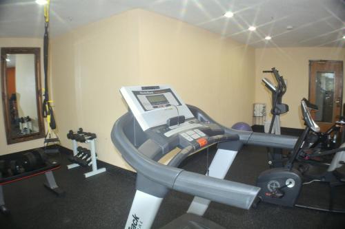 a room with a gym with a treadmill and weights at Baymont by Wyndham Muskegon in Muskegon