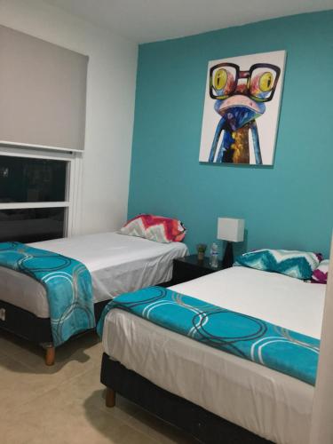 Habitación con 2 camas y una pintura en la pared. en Dream Lagoons, en Cancún