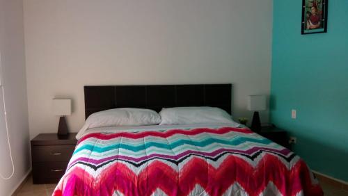 Un dormitorio con una cama con una manta de colores. en Dream Lagoons, en Cancún