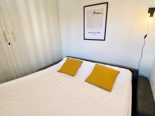 een bed met twee gele kussens erop bij Studio Mont-de-Lans, 1 pièce, 4 personnes - FR-1-516-171 in Les Deux Alpes