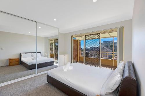 Un dormitorio con dos camas y una gran ventana. en Taylor Apartment, en The Entrance