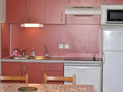 une cuisine avec des armoires rouges, un évier et un réfrigérateur dans l'établissement 3 Pièces Cabine avec Balcon et Parking à Font-Romeu - FR-1-580-57, à Font-Romeu-Odeillo-Via
