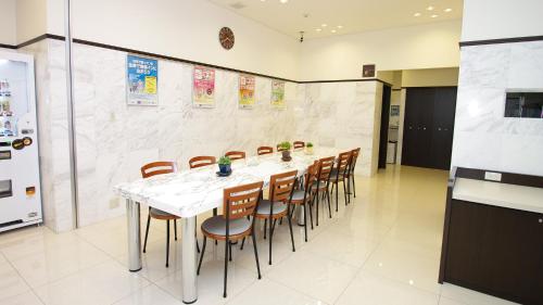 a dining room with a long table and chairs at Toyoko Inn Chiba Shin kamagaya Ekimae in Kamagaya