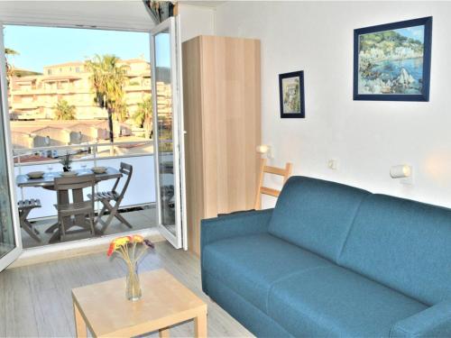 un salon avec un canapé bleu et une table dans l'établissement Studio rénové climatisé, 3 couchages, proche port et casino à Cavalaire-sur-Mer - FR-1-226B-98, à Cavalaire-sur-Mer