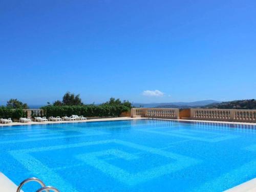 une grande piscine avec de l'eau bleue et des chaises dans l'établissement Studio familial avec terrasse, piscine, tennis et parking aux Issambres - FR-1-226-473, à Saint-Peïre-sur-Mer