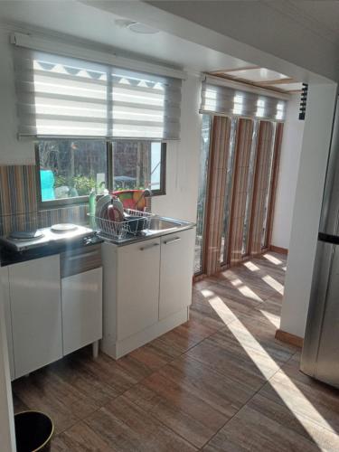 a kitchen with a sink and a window with blinds at Tu Jardín Secreto in La Serena
