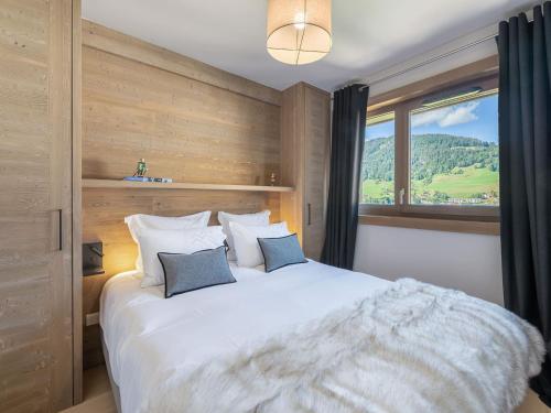 1 dormitorio con 1 cama blanca grande y ventana en Appartement Megève, 5 pièces, 8 personnes - FR-1-569-31, en Megève