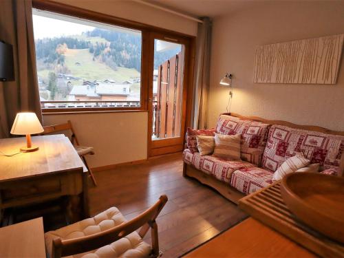 un salon avec un canapé et une grande fenêtre dans l'établissement Appartement douillet à la montagne, 2-3 pers., balcon, près des commerces - FR-1-342-262, à Beaufort