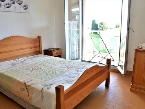- une chambre avec un lit et un balcon avec une chaise dans l'établissement Appartement Climatisé 2P avec Parking, Proche Plage et Commerces à Cavalaire - FR-1-226B-99, à Cavalaire-sur-Mer