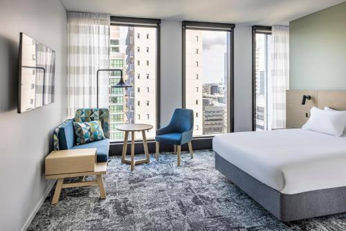 a hotel room with a bed and a chair at Holiday Inn Express Auckland City Centre by IHG in Auckland