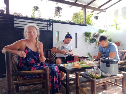 a group of people sitting around a table eating food at Banyuwangi Homestay in Banyuwangi