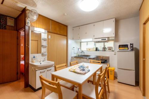 a kitchen with a table and chairs and a refrigerator at M`Sリゾート若狭@LiB PLUS in Tomari