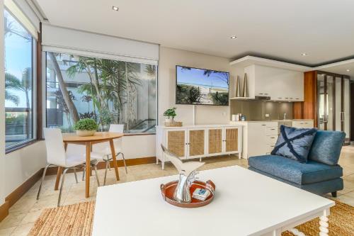 a kitchen and living room with a table and chairs at Santai Sea-Duction in Casuarina