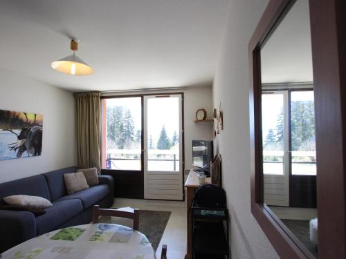 a living room with a couch and a table at Appartement Chamrousse, 2 pièces, 5 personnes - FR-1-549-83 in Chamrousse