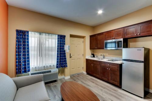 a kitchen with wooden cabinets and a white refrigerator at Captains Quarters Inn in Port Aransas