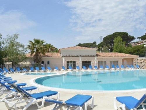 une grande piscine avec des chaises et des chaises bleues dans l'établissement Sainte-Maxime : 3 Pièces, 4 Couchages, Piscine, Calme, Proche Commerces et Aqualand - FR-1-226-476, à Sainte-Maxime