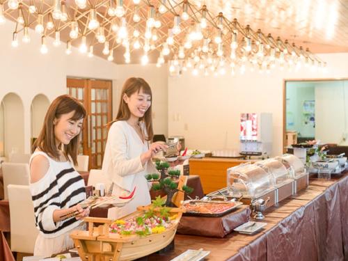 2 vrouwen serveren eten in een buffet bij LiVEMAX RESORT Ito Kawana in Ito