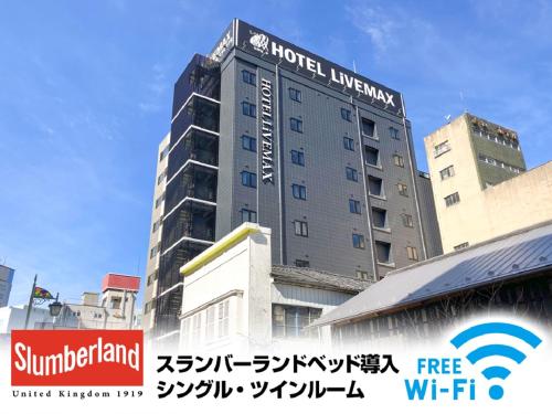 a hotel building with a sign on top of it at HOTEL LiVEMAX Sendai Hirosedori in Sendai
