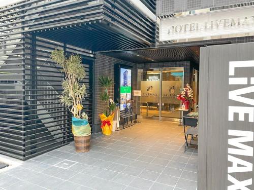 a store entrance with plants in a building at HOTEL LiVEMAX Sendai Hirosedori in Sendai