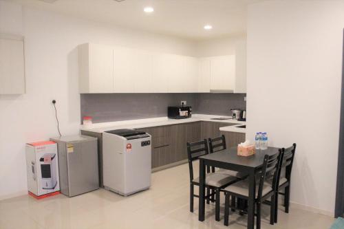 a kitchen with a table and chairs and a refrigerator at Suasana Suites D'Homestay2 JB Town in Johor Bahru