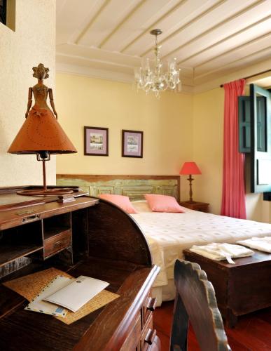 a bedroom with a bed and a desk with a lamp at Hotel Villa Bahia in Salvador