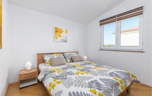 een witte slaapkamer met een bed en een raam bij Awesome Apartment In Valbandon With Wifi in Valbandon