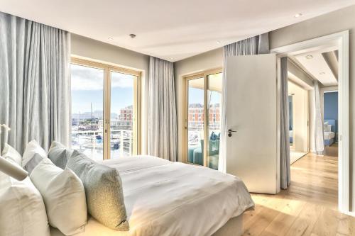 1 dormitorio con 1 cama grande y ventana grande en Superior Three Bedroom Apartment en Ciudad del Cabo