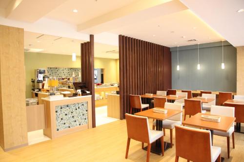 a restaurant with tables and chairs and a counter at Urban Hotel Kusatsu in Kusatsu