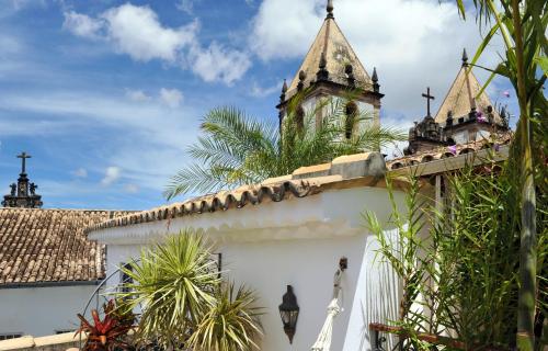 a white building with a clock tower on top of it at Hotel Villa Bahia in Salvador