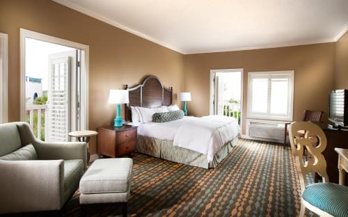 a bedroom with a bed and two windows and a couch at Boardwalk Inn in Kemah