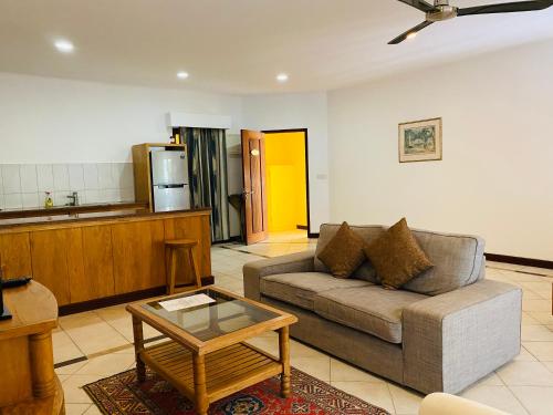 a living room with a couch and a table at Pieds Dans L’Eau Holiday Apartments in Mahe