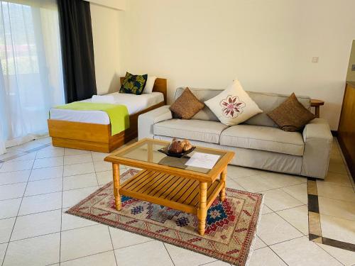 a living room with a couch and a coffee table at Pieds Dans L’Eau Holiday Apartments in Mahe