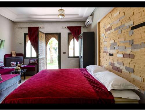 a bedroom with a large bed with a brick wall at Palace with 2 villas and 2 swimming pools in Sidi Abdellah Ghiat in Had Abdallah Rhiat