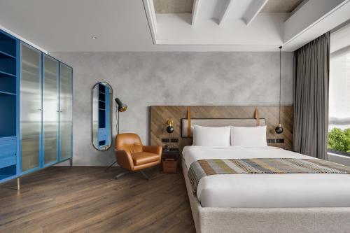 a bedroom with a bed and a desk and a chair at The Denizen 真寓 in Taipei