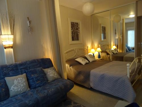 une chambre avec un lit, un canapé et un miroir dans l'établissement Rez-de-Jardin T3/4 avec Jardin, Parking Privé - Proche Plage et Centre-ville - FR-1-92-910, à Les Sables-dʼOlonne