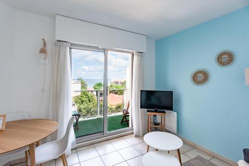 a living room with a table and a large window at Superbe vue bassin/PARK/WIFI in Arcachon