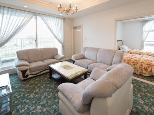 a living room with a couch and a bed at Spa Resort LiVEMAX in Mooka
