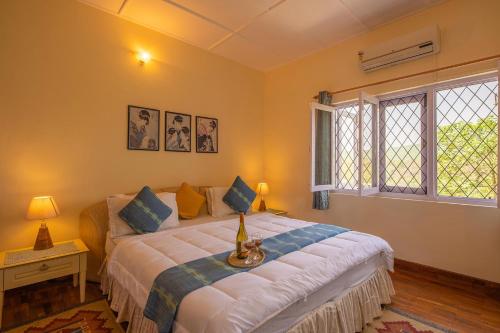 un dormitorio con una cama y una ventana en Bamboo Grove by VEO - Part of StayVista, en Dehradun