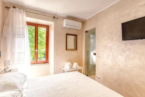a bedroom with a white bed and a window at Oasi Borghetto Verde in Castellaro