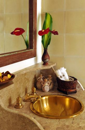 a sink in a bathroom with a mirror and a vase with flowers at Hotel Villa Bahia in Salvador