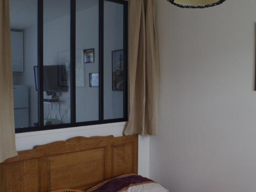 une chambre avec un lit et un grand miroir dans l'établissement Maison Proche Plage avec Jardin, Terrasse et WIFI à Le Palais - Parfait pour Familles - FR-1-418-182, au Palais